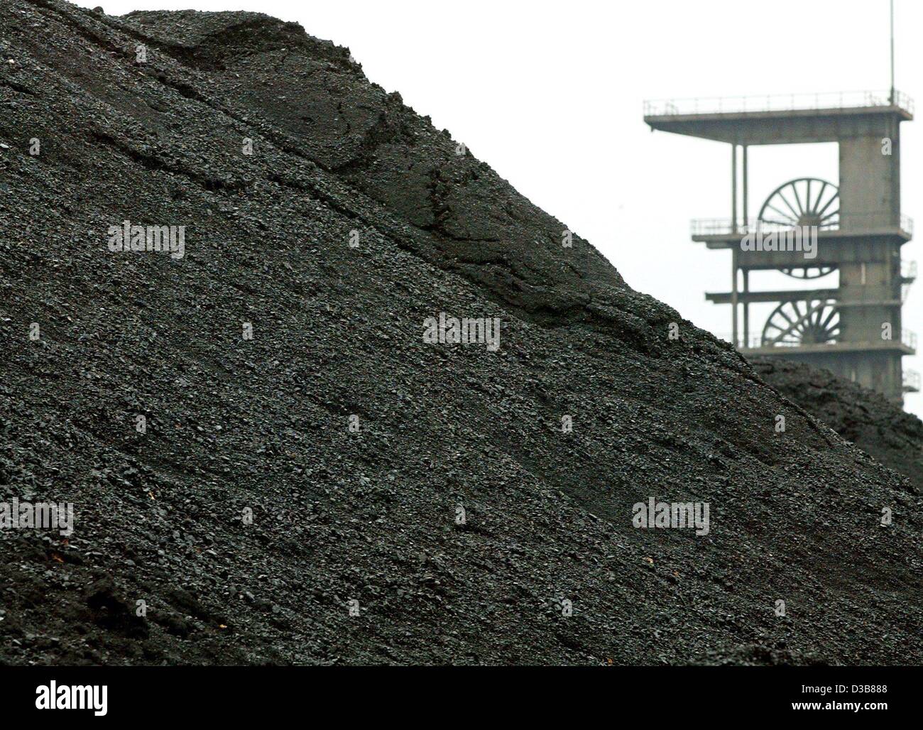 (Afp) - L'ancien derrick de forage est vu derrière un énorme tas de charbon à la mine de charbon de prospérer à Bottrop, Allemagne, 13 novembre 2002. La société minière de Essen RAG est de fermer deux plus de charbon jusqu'en 2007. En ce moment, dix mines de houille sont encore en exploitation en Allemagne. Banque D'Images