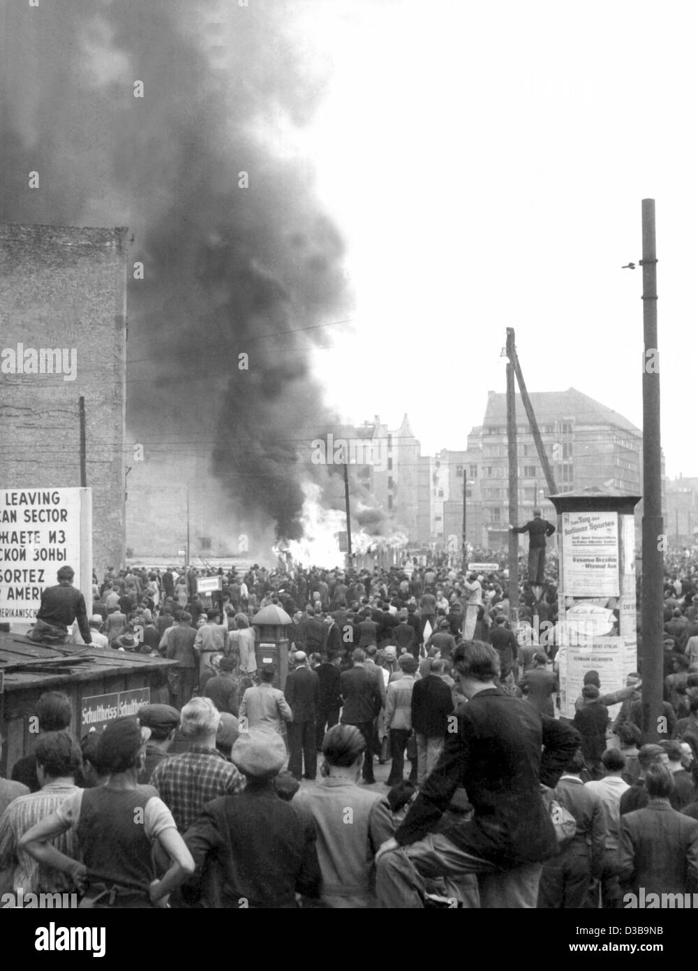 (Afp) - dans le Berlinois de l'ouest du secteur américain se tenir au passage de la frontière, et regarder un kiosque qui a parti en fumée à Friedrich Strasse dans le secteur soviétique, illustrée de l'ouest de Berlin, le 17 juin 1953. Émeutes contre le régime communiste à Berlin est augmenté lorsque les grèves et un d Banque D'Images