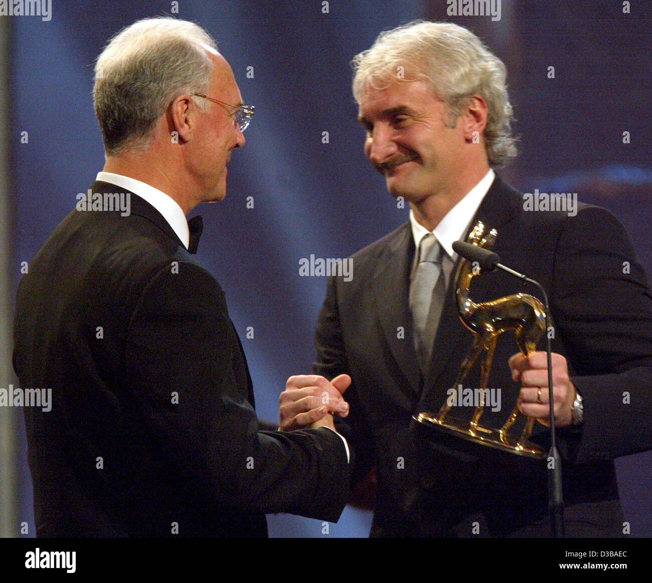 (Afp) - "la légende du football allemand Franz Beckenbauer Kaiser' (L), serre la main avec Rudi Voeller, entraîneur de l'équipe de football allemande, à qui il a présenté le Bambi award dans la catégorie 'Sports' à la Bambi award show dans l'Estrel Convention Center à Berlin, le 21 novembre 2002. Environ 1 000 invités un Banque D'Images