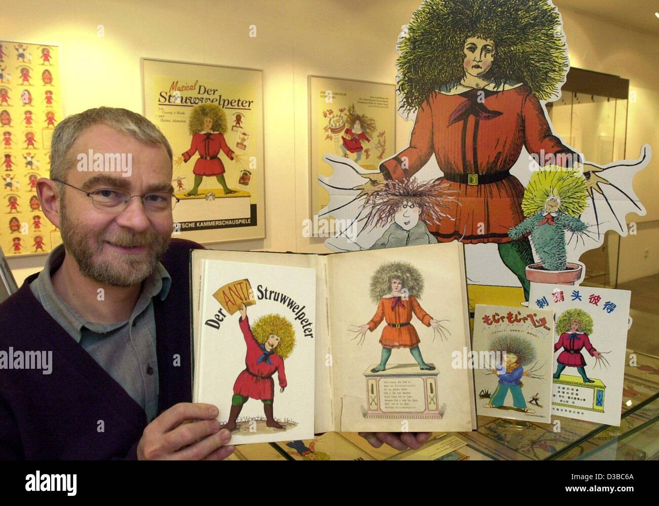 (Afp) - Voelker-Jansen Wilhelm, directeur de la ville de Willingen, Allemagne Musée, présente une collection d'éditions étrangères et historiques de la "truwwelpeter' Pierre (choc), 25 octobre 2002. Le monde célèbre 160 ans figure réalisée par le médecin Dr Heinrich Hoffmann est présentée dans une ex Banque D'Images
