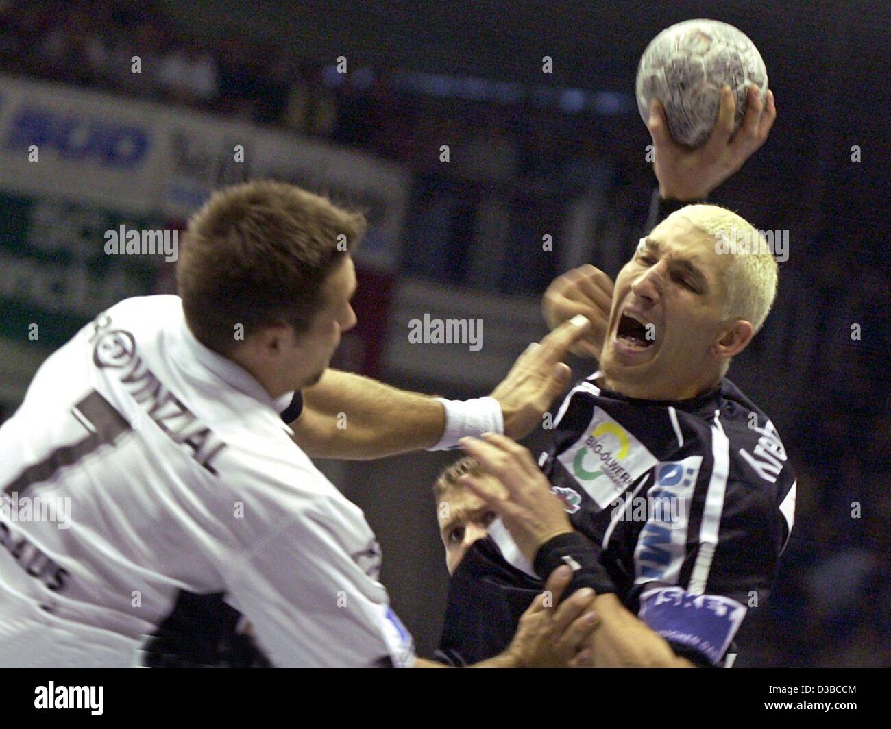 (Afp) - Magdeburg's player Stefan Kretzschmar tente de lancer la balle passé Kiel's Morten Bjerre du Danemark au cours de la Bundesliga match de Hand SC Magdeburg contre Holstein Kiel à Magdeburg, Allemagne, 12 octobre 2002. Magdeburg gagne contre le tenant du titre Kiel 30:29. Banque D'Images