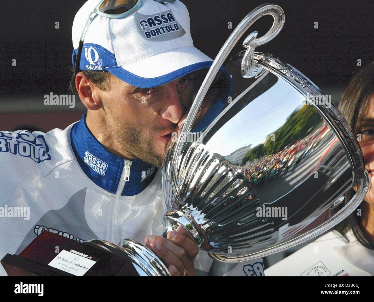 (Afp) - le cycliste italien Michele Bartoli de l'équipe Fassa Bartolo embrasse son trophée après sa victoire de la 96e Tour de Lombardie à Bergame, Italie du nord, 19 octobre 2002. Bartoli a terminé les 251 km de la "Giro di Lombardia" en 6 heures, 14 minutes et 49 secondes. Banque D'Images