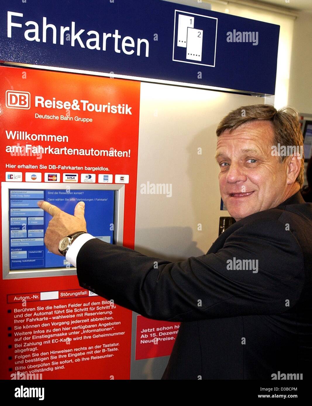 (Afp) - Hartmut Mehdorn, président de la compagnie ferroviaire allemande Deutsche Bahn (DB), les points à l'écran d'un distributeur de tickets à un maching gare de Berlin, 9 octobre 2002. La Deutsche Bahn a annoncé de nouveaux prix pour les billets de train, qui entrera en vigueur le 15 décembre. Billets pour de longues dista Banque D'Images