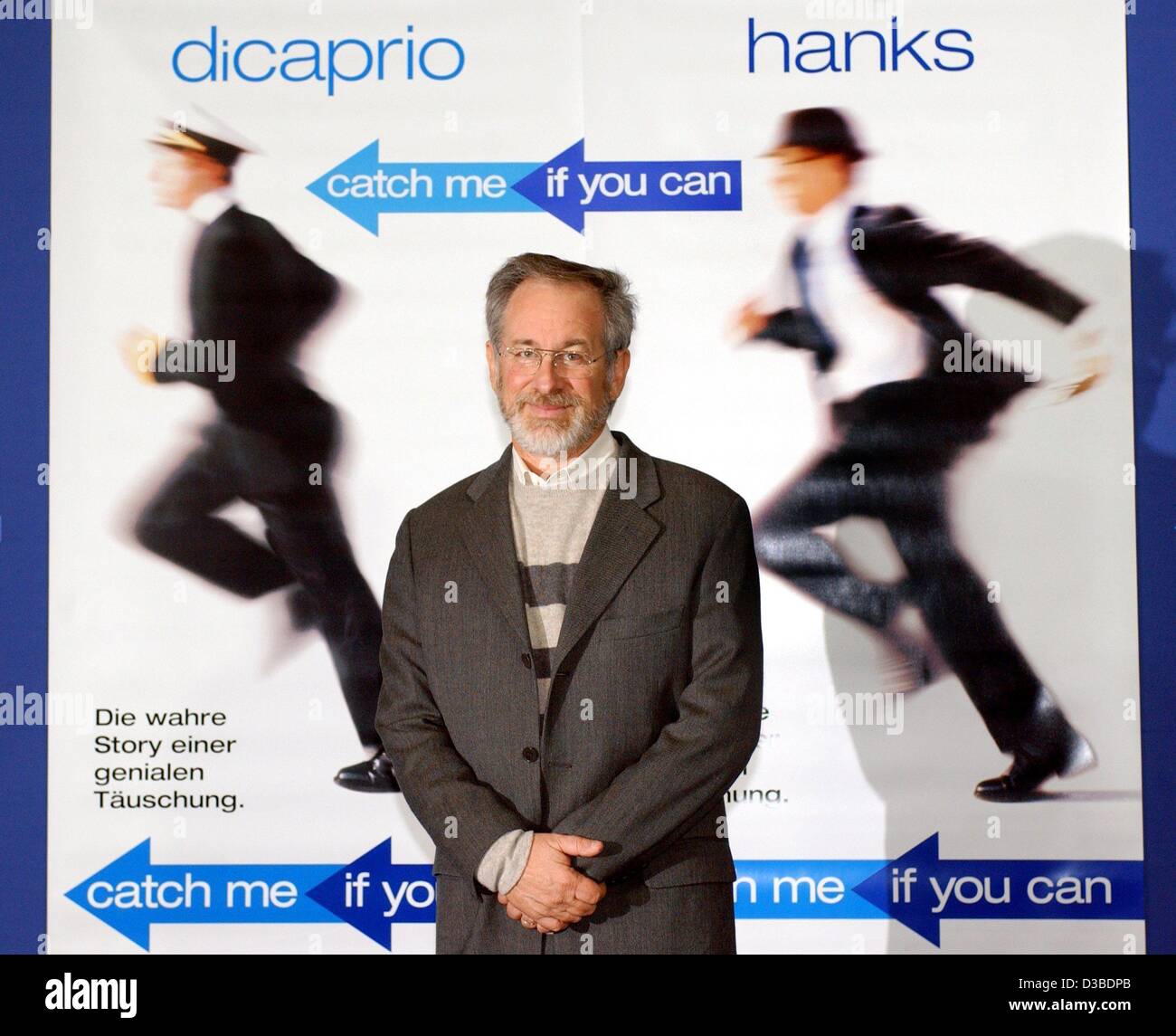 (Afp) - le réalisateur américain Steven Spielberg pose devant une affiche de film en avant de la première Allemande de son nouveau film "Arrête-moi si tu peux" à Berlin, le 26 janvier 2003. Le film, basé sur une histoire vraie, est sur la réussite d'un artiste qui parvient à se faire passer pour plusieurs identités alors que chas Banque D'Images