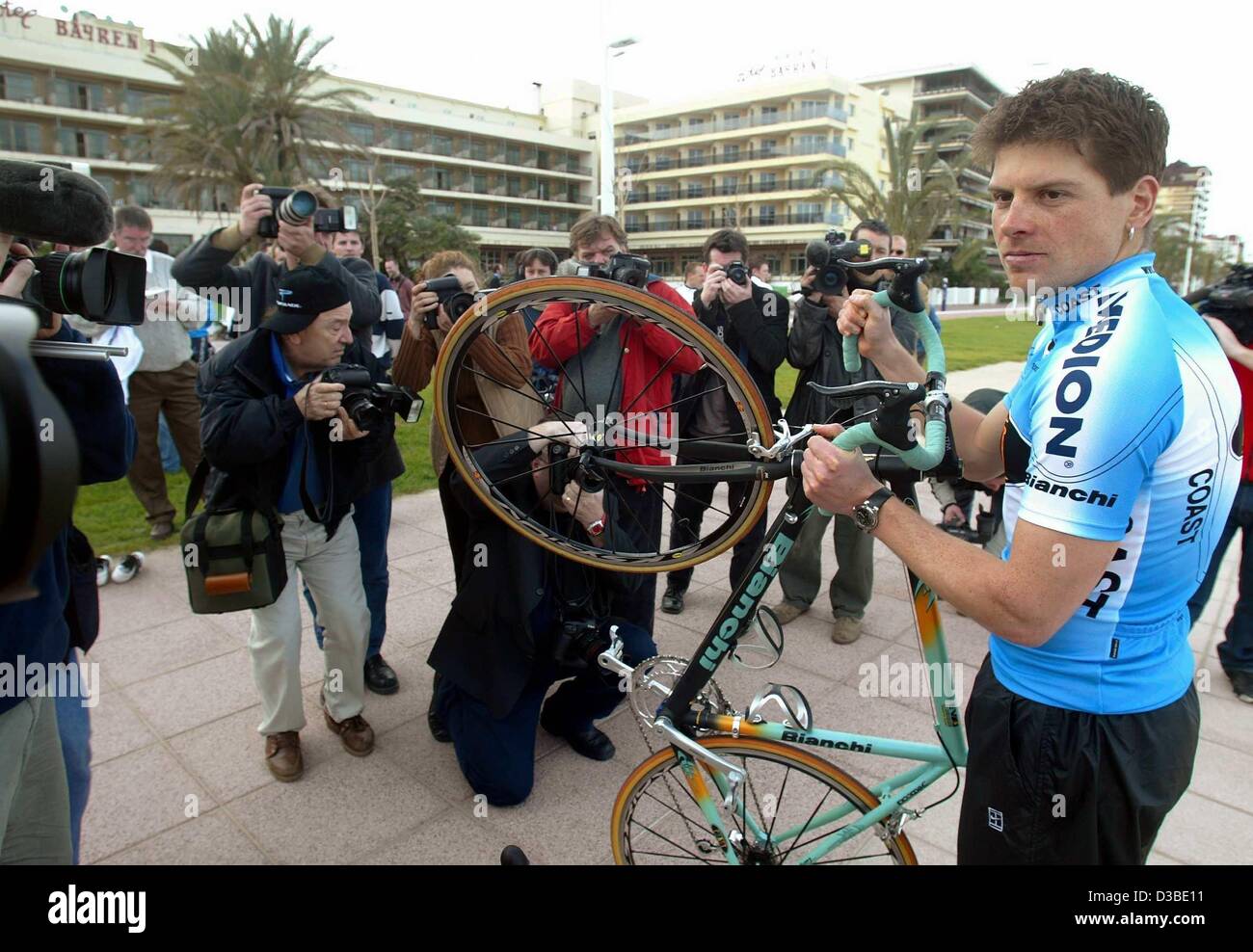 (Afp) - Jan Ullrich, le cyclisme allemand professionnel de l'équipe de la côte, est entouré par les photographes et les équipes de l'appareil photo à Gandia, Espagne, 20 janvier 2003. Au cours d'une journée d'ouverture, l'équipe cycliste professionnelle de Essen, Allemagne, se présente aux médias. Champion du monde de cyclisme Jan Ullrich a tr Banque D'Images