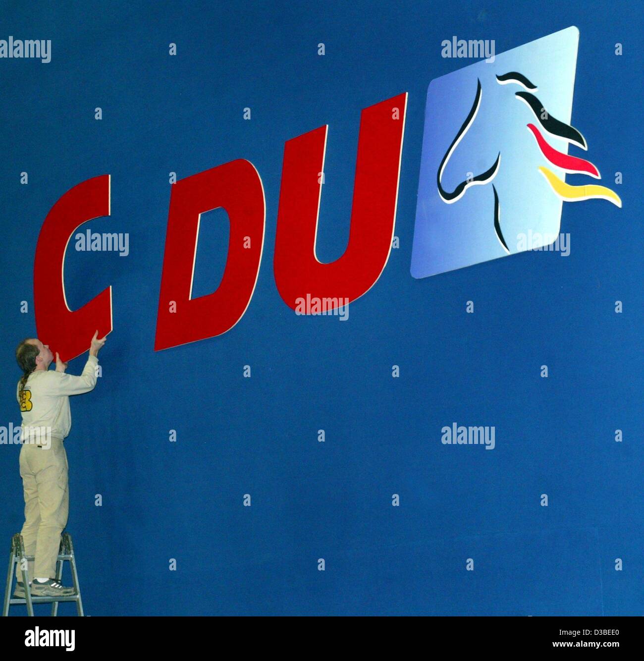 (Afp) - Un homme est en train de noter le 'C' de la CDU logo dans Braunschweig, Allemagne, 12 janvier 2003. Les chrétiens-démocrates ont commencé la campagne électorale de Basse-Saxe à Braunschweig. Environ 6,1 millions de dollars de moins Saxonians votent un nouveau parlement européen, le 2 février 2003. Banque D'Images