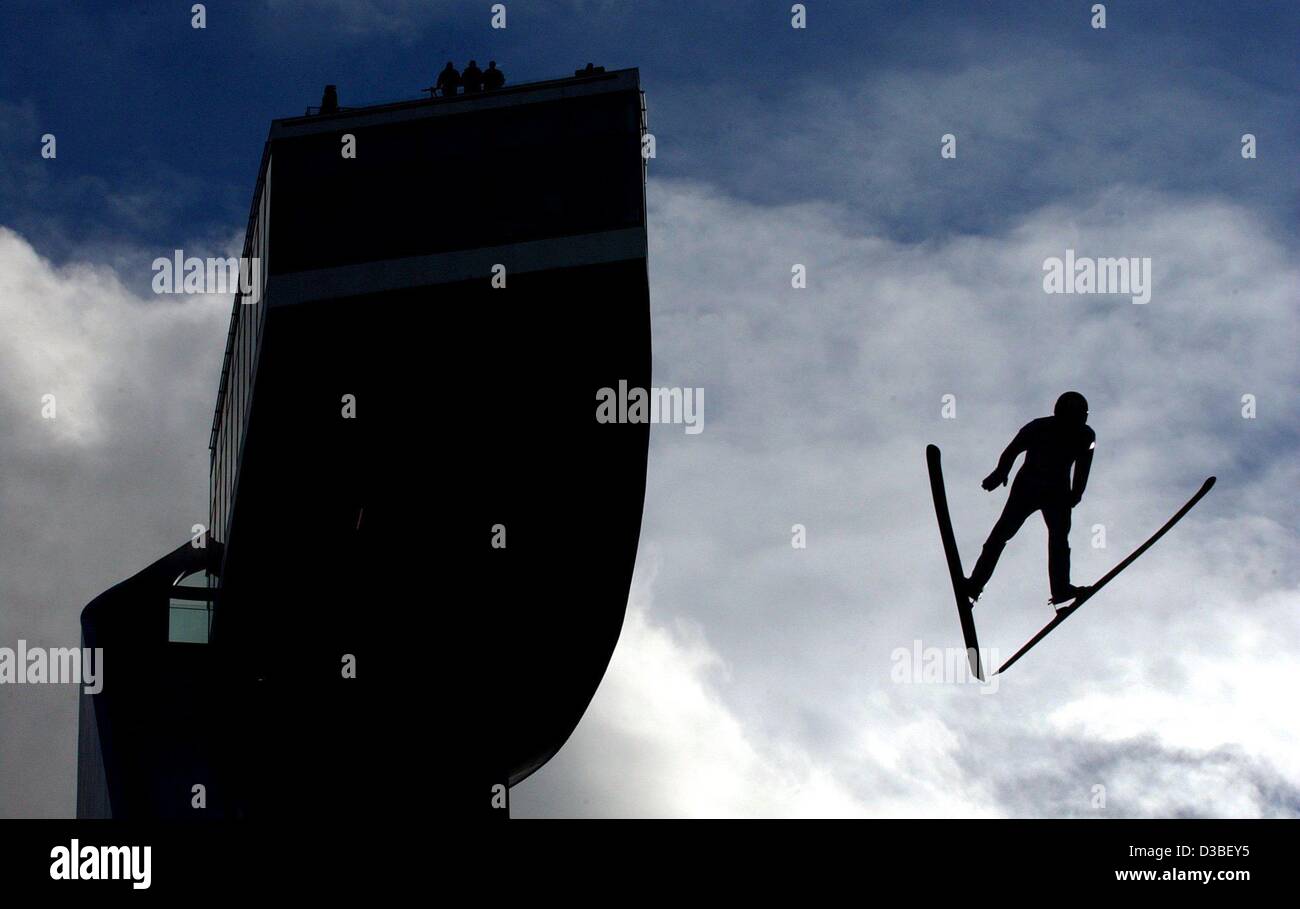 (Afp) - un cavalier de ski s'envole le saut Bergisel en face de nuages avec lumière arrière lors de la 51e tournoi quatre Hill à Innsbruck, Autriche, 4 janvier 2003. Banque D'Images