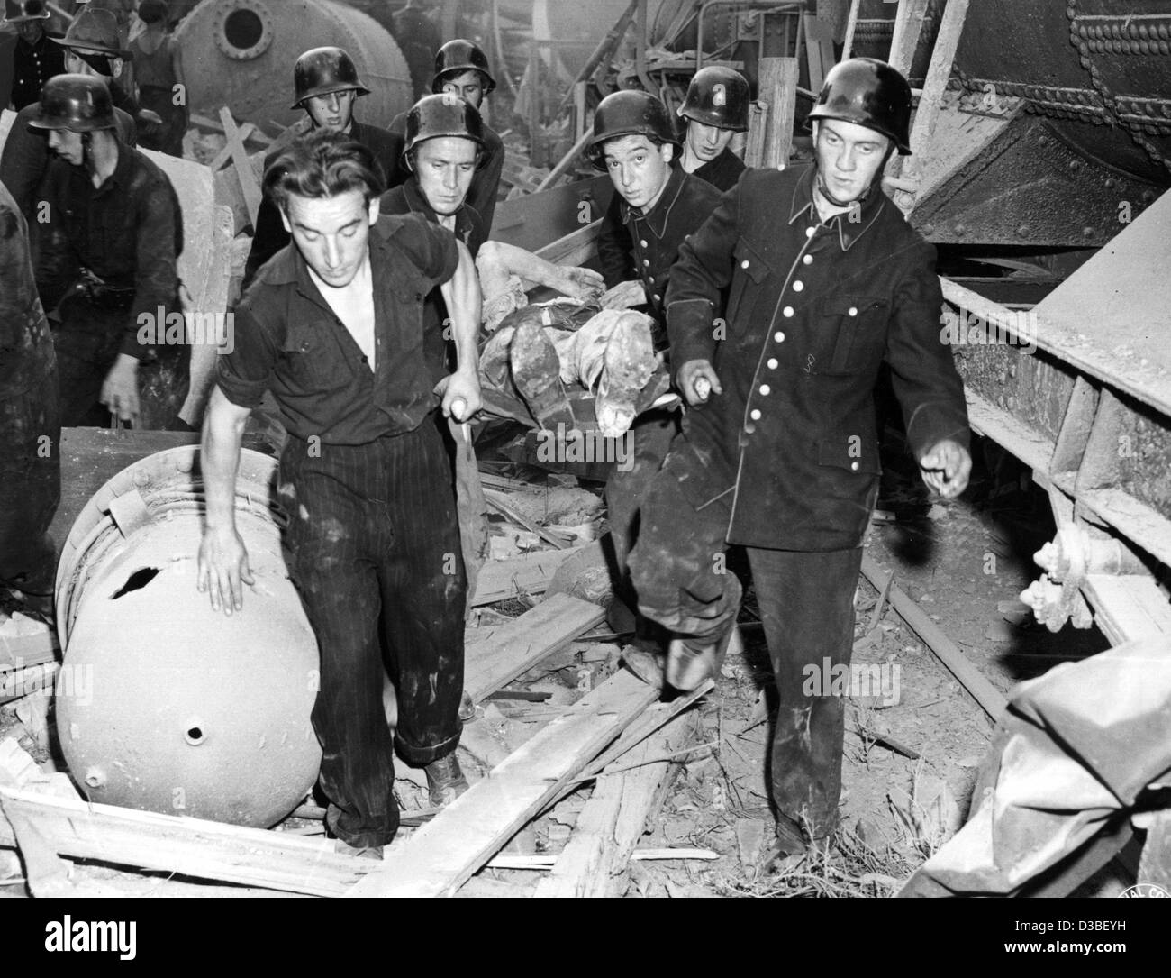 (Afp) - Les secouristes porter loin l'une des victimes de l'explosion chimique à l'usine chimique de BASF à Ludwigshafen, Allemagne de l'après-guerre, le 28 juillet 1948. 207 personnes ont été tuées, environ 3 800 blessés et des dommages ont été causés par l'explosion d'une citerne à bogies, chargé avec l'éther, sur le fa Banque D'Images