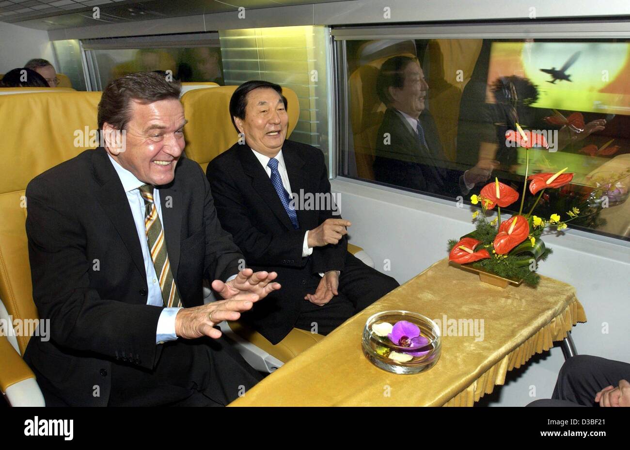 (Afp) - Le Premier ministre chinois Zhu Rongji (R) et le chancelier allemand Gerhard Schroeder profiter le voyage inaugural de la première commericial la lévitation magnétique (Maglev) train à une vitesse de plus de 400 km par heure, à Shanghai, 31 décembre 2002. La première suspension magnétique transrapid ra Banque D'Images