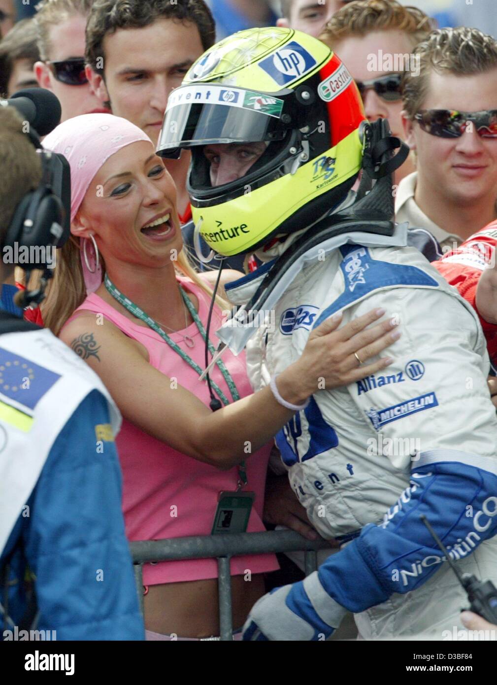 (Afp) - un pilote Le pilote allemand Ralf Schumacher (Williams-BMW) hugs heureusement sa femme Cora après avoir remporté le Grand Prix d'Europe au Nürburgring race track, Allemagne, 29 juin 2003. Avec 43 points au classement général pour les championnats du monde, il est maintenant le troisième rang. Banque D'Images
