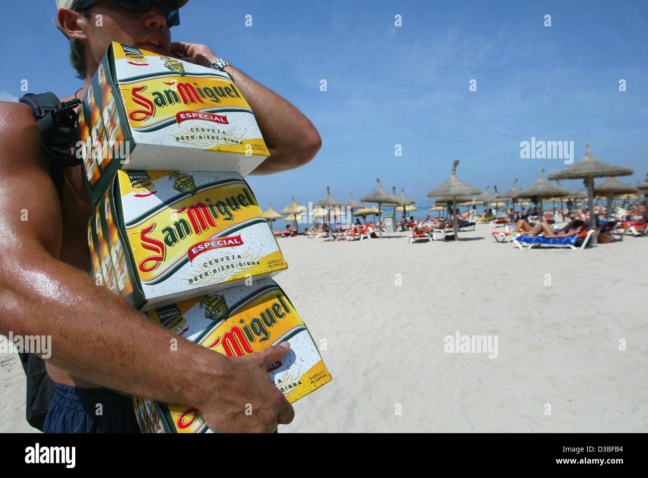 (Afp) - le voyageur porte un trois six-pack de bière le long de la plage à El Arenal près de Palma sur l'île de Majorque, Espagne, 9 juin 2003. Majorque est la plus grande des îles Baléares avec un paysage varié et une riche histoire culturelle. Les Arabes a jugé les Baléares jusqu'à ce qu'ils nous Banque D'Images