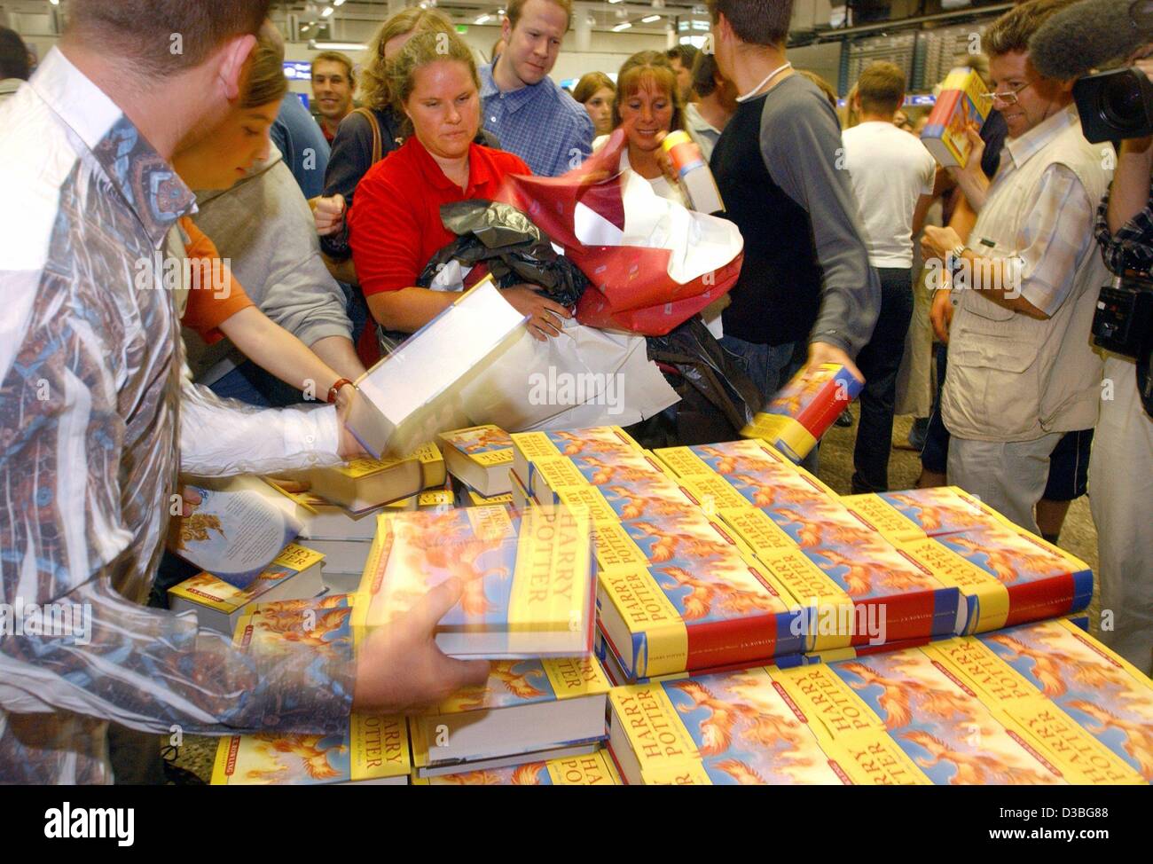 (Afp) - Harry-Potter-Fans prenez la première copie de la dernière édition de Harry Potter dans une librairie à l'aéroport de Francfort-sur-Main, Allemagne, 21 juin 2003. La dernière édition de "Harry Potter et l'Ordre du Phénix' est imprimé uniquement en anglais et est maintenant disponible en Allemagne. L'édition allemande de wil Banque D'Images