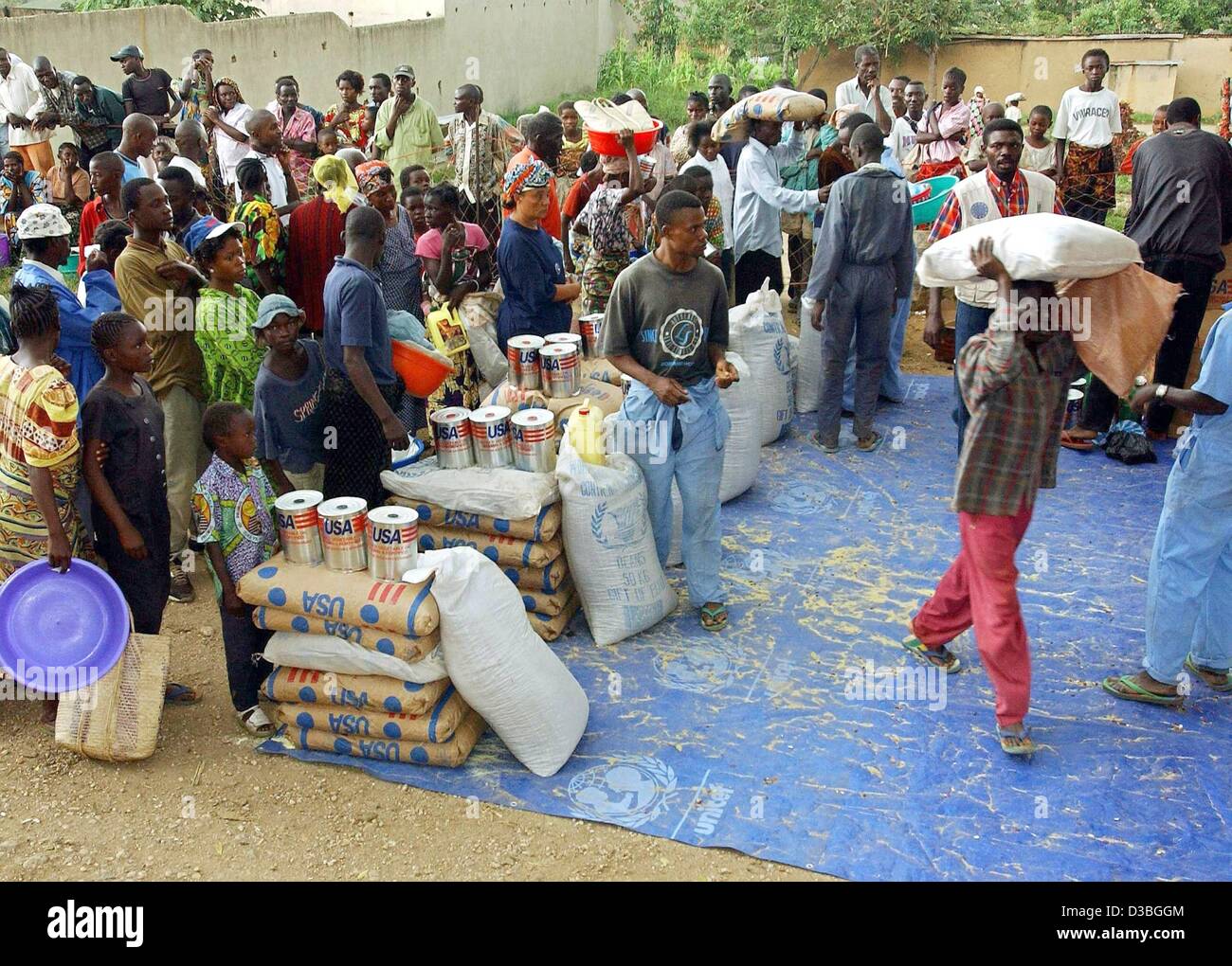 (Afp) - les réfugiés de l'aide humanitaire de la file d'autres réfugiés qui aident à distribuer à la MONUC, composé d'un camp dans l'est de la ville de Bunia, en République démocratique du Congo, 16 juin 2003. Environ 10 000 réfugiés vivent dans ce camp. Selon des rapports d'employés de l'allégement organisat Banque D'Images