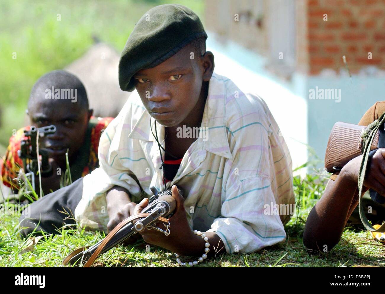 Afp) - Un groupe d'enfants soldats de l'Union des patriotes congolais (UPC) couche avec fusil à la main sur le sol lors d'un exercice de tir réel à la périphérie de Bunia, en République démocratique du Congo, le 14 juin 2003. La milice UPC se compose principalement de membres de l'ethnie Hema et beaucoup de personnes Banque D'Images