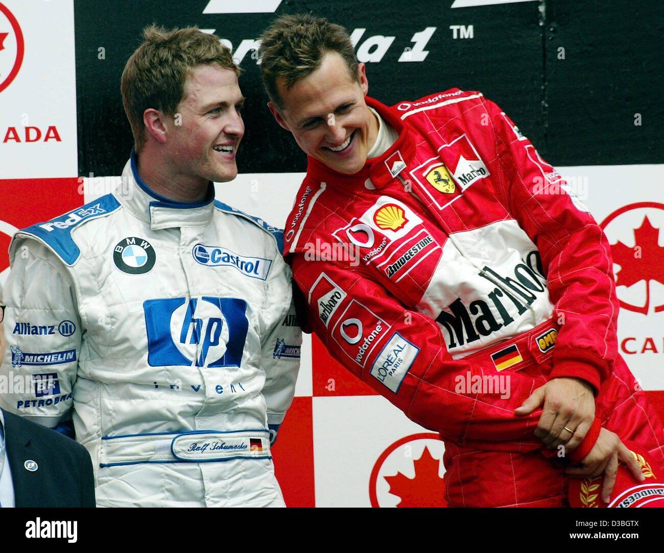 (Afp) - L'allemand champion du monde de Formule 1 Michael Schumacher (Ferrari) (R) se distingue avec son frère pilote de Formule 1 allemand Ralf Schumacher pendant la cérémonie de remise des prix sur le circuit Gilles Villeneuve de la formule 1 après le Grand Prix du Canada à Montréal, Canada, 15 juin 2003. Michael Sc Banque D'Images