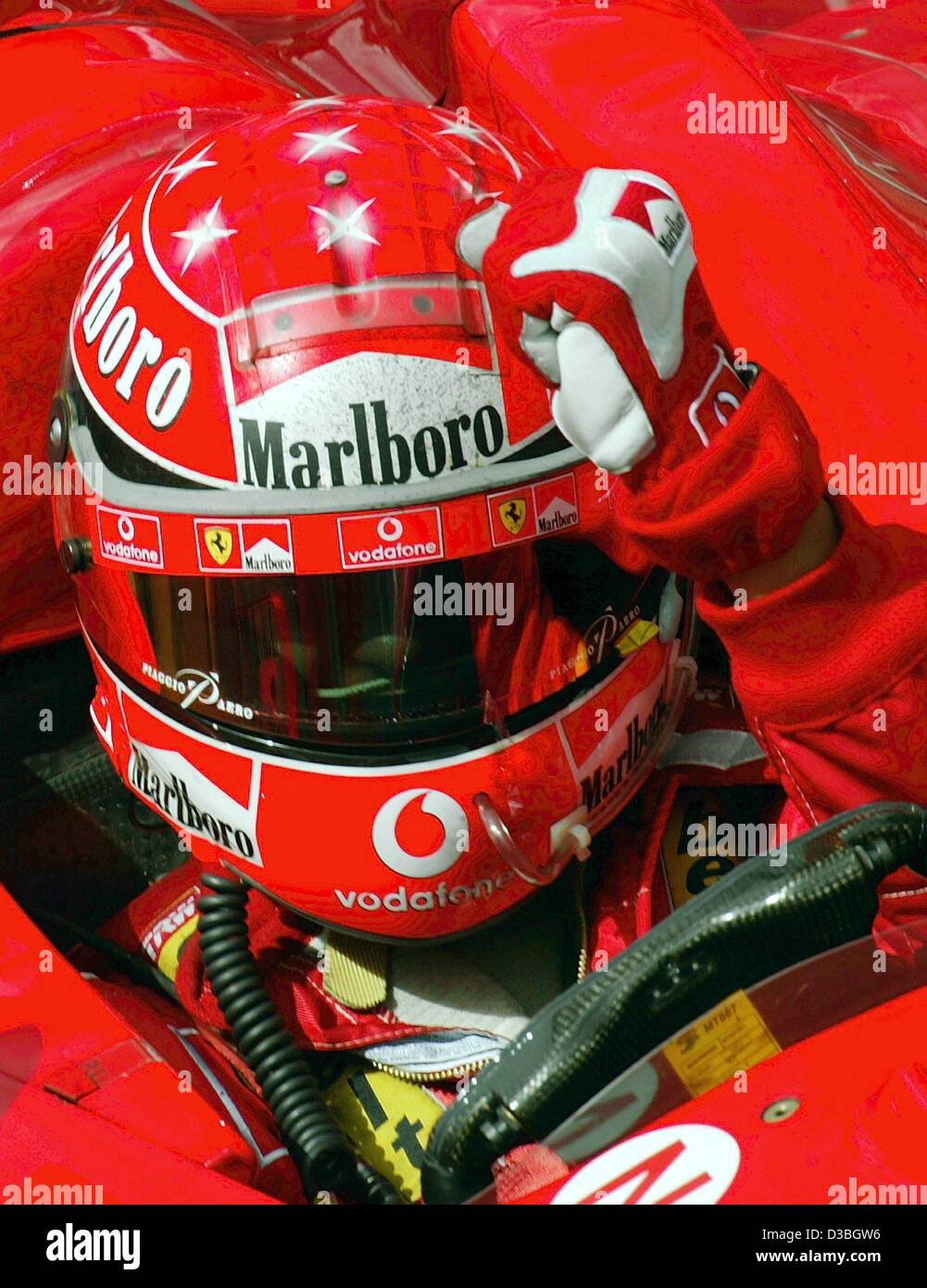 (Afp) - L'allemand champion du monde de Formule 1 Michael Schumacher (Ferrari) frappe sa main à son casque comme un geste indiquant qu'il a bientôt après avoir remporté le Grand Prix du Canada sur le circuit Gilles Villeneuve circuit de Formule 1 à Montréal, Canada, 15 juin 2003. Michael Schumacher remporte le r Banque D'Images
