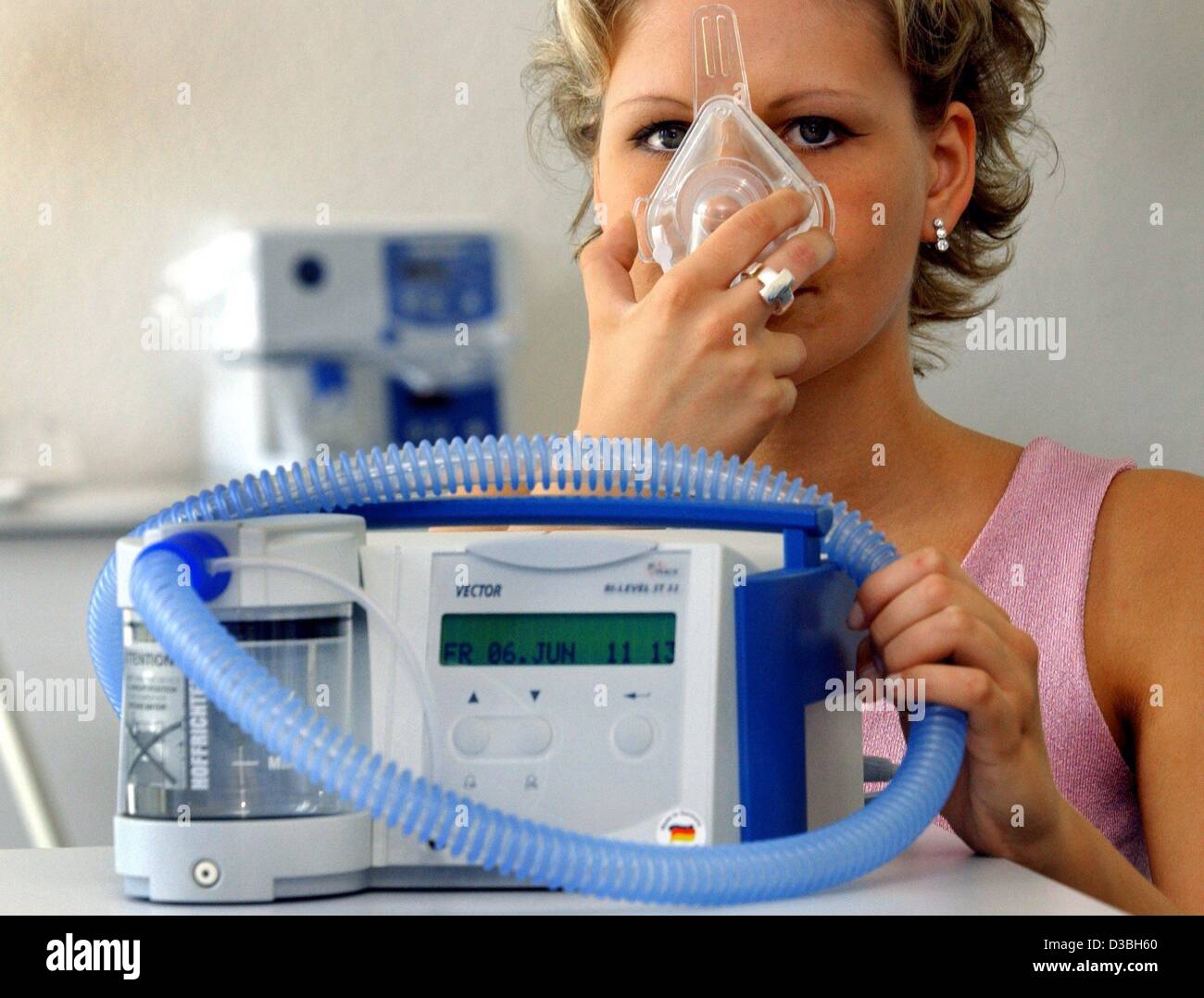 (Afp) - une femme démontre le fonctionnement de l'appareil de thérapie respiratoire 'Vector' de la société Hoffrichter à Schwerin, Allemagne, 10 juin 2003. L'entreprise a livré plus de 1000 de ces appareils à la Chine pour le traitement des patients atteints du SRAS. Habituellement le masque respiratoire est utilisé pour éviter de l'apn Banque D'Images