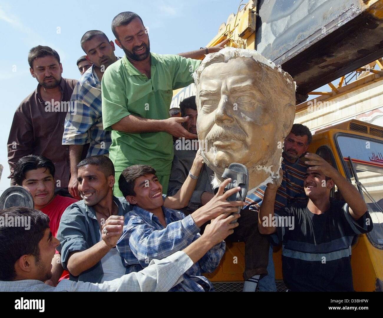 (Afp) - le chef de battre les Irakiens le Président Saddam Hussein a déchiré de sa statue à Bagdad, Iraq's capital, 14 avril 2003. Banque D'Images