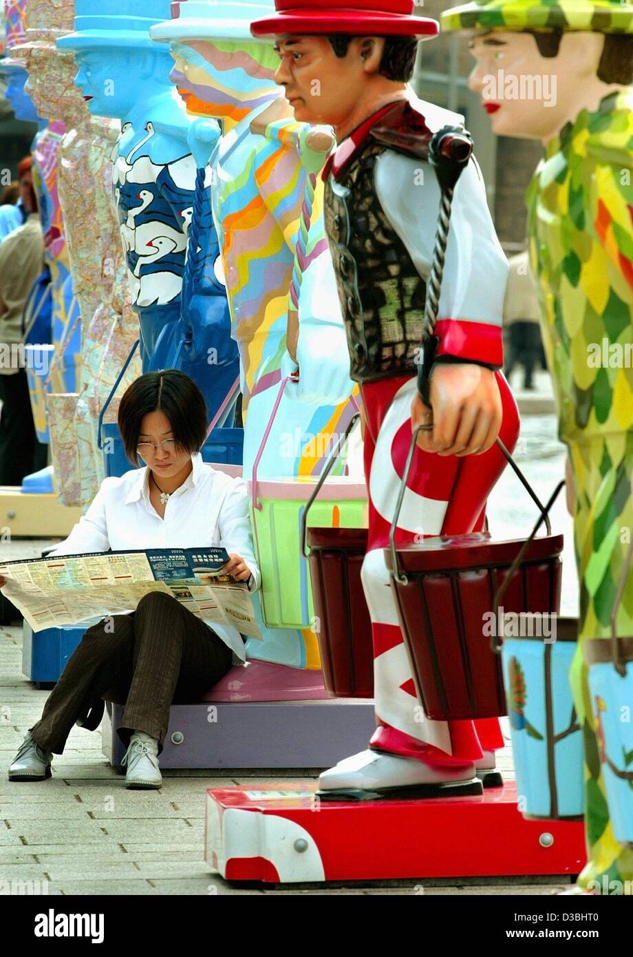 (Afp) - une jeune femme est assise en face d'une sculpture grandeur nature de "Hans Hummel' et des études sur un plan de Hambourg, Allemagne, 3 juin 2003. Le modèle de cette sculpture est le héros local et porteur d'eau Hans Hummel (1787-1854) dont le vrai nom était Johann Wilhelm Bentz. 100 statues ont été mis en place dans le Banque D'Images