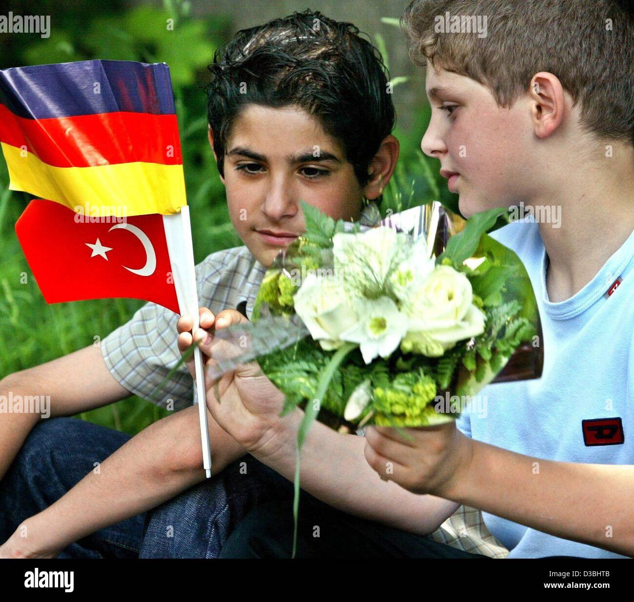 (Afp) - deux enfants avec des drapeaux turcs et allemands et un bouquet de fleurs à assister à un service commémoratif pour célébrer le dixième anniversaire de l'incendie criminel dans une famille turque chambre à Solingen, Allemagne, 29 mai 2003. Cinq membres de la famille ont été tués dans l'incendie criminel de leur maison par la droite Banque D'Images