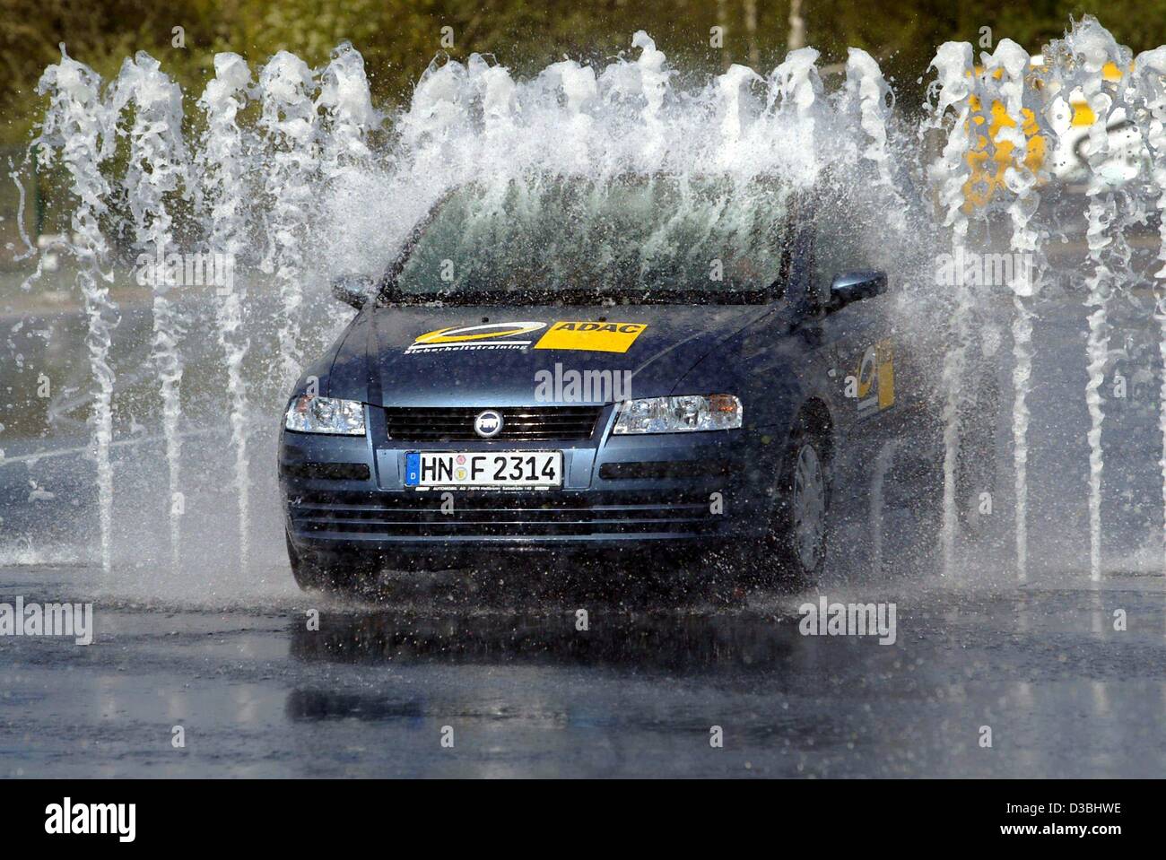 (Afp) - une voiture conduit par l'eau des fontaines, qui a soudainement tourner hors de la terre sur l'ADAC (général allemand automobil club) la masse de forage pour plus de sécurité au volant à Coblence, Allemagne, 15 avril 2003. Balade à moto et les conducteurs peuvent apprendre à faire face à diverses situations dangereuses et soudain barricad Banque D'Images