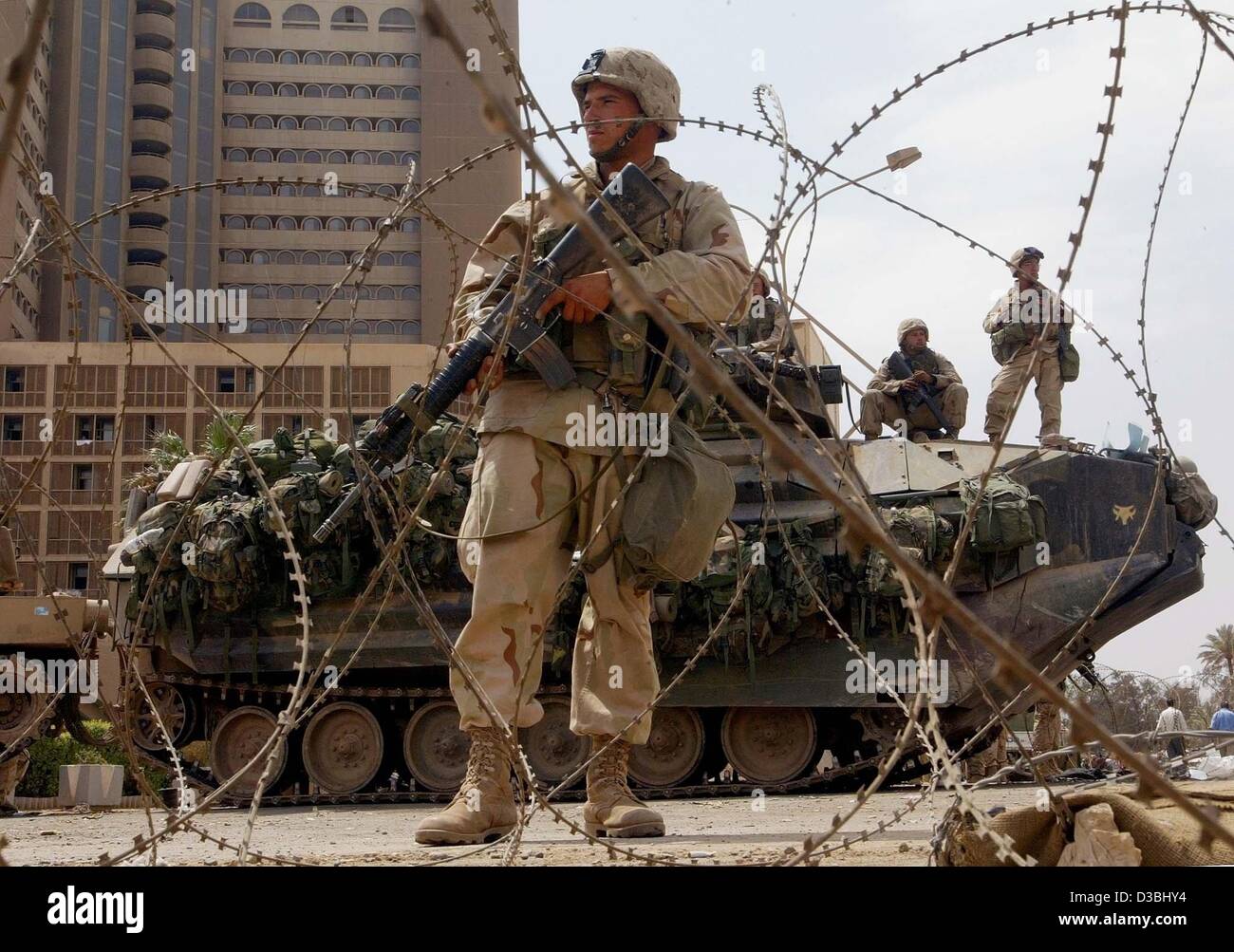 (Afp) - Des soldats de l'armée US montent la garde devant l'entrée principale de l'hôtel Palestine à Bagdad, 15 avril 2003. Quelque 300 irakiens se sont rassemblés devant l'hôtel, où les marines américains ont mis en place une base d'opérations, pour une troisième journée consécutive de manifestations contre l'occupation américaine. La plupart de l'international Banque D'Images