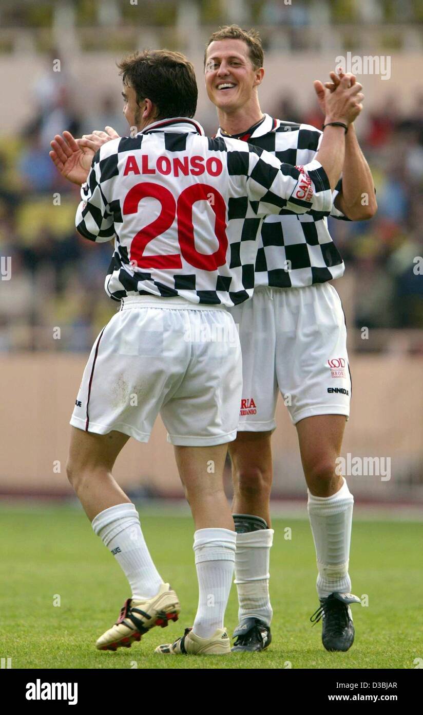 (Afp) - Le champion du monde de Formule 1 l'Allemand Michael Schumacher (R) et l'Espagnol Fernando Alonso pilote de F-1 célèbrent le but d'Alonso à un match de football de bienfaisance à Monte Carlo, 27 mai 2003. Quelques jours avant le Grand Prix l'équipe de conducteurs Schumacher 'Nazionale Piloti' et 'St du Prince Albert Banque D'Images