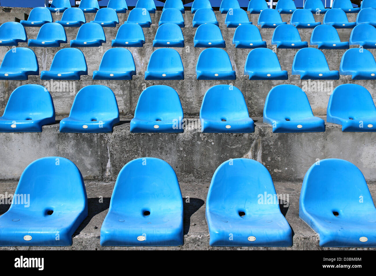 Sièges en plastique bleu ancien stade concernant des mesures concrètes Banque D'Images