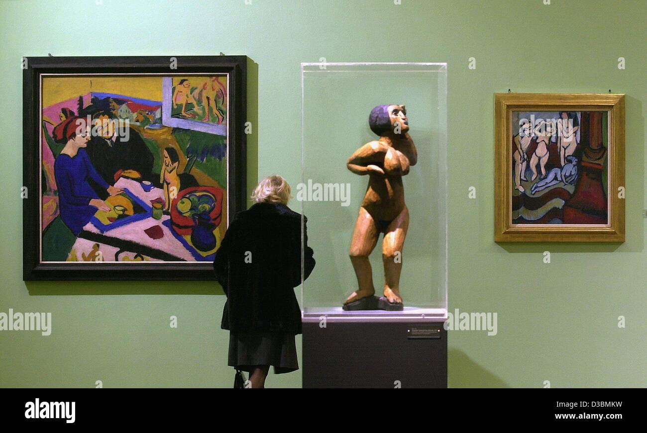 (Afp) - Une femme regarde les peintures et sculptures de l'artiste expressionniste allemand Ernst Ludwig Kirchner (1880-1938) à la Staatsgalerie (galerie d'état) à Stuttgart, Allemagne, 10 avril 2003. La peinture à l'huile sur le côté gauche est intitulé 'Doris' am Tisch und Heckel (Doris et Heckel à la table, 1910/ Banque D'Images