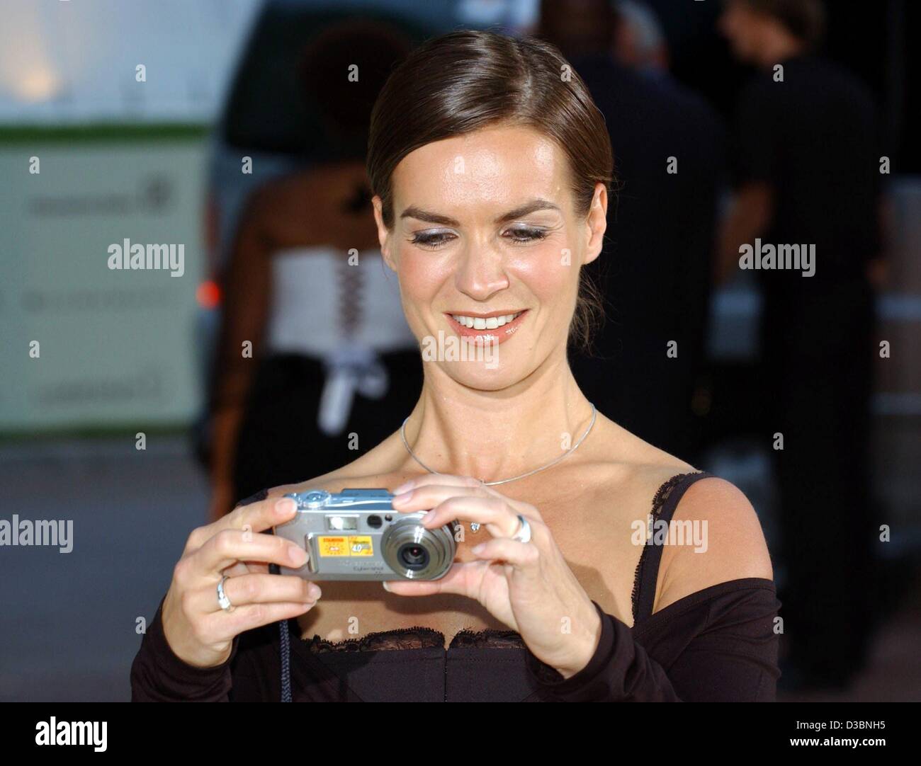 (Afp) - Kati Witt, ancienne star de patinage artistique, prend des photos avec son appareil photo alors qu'elle arrive pour le dîner de gala pour les Laureus Award au sports club à Monte Carlo, 19 mai 2003. La "Laureus World Sports Award" sera présenté le 20 mai 2003 à Monte Carlo pour la quatrième fois. Banque D'Images