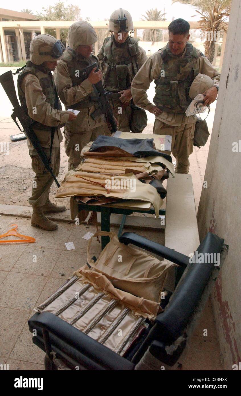 (Afp) - Les Marines américains inspecter vestes ils trouvés pendant les opérations de déminage à Bagdad, 13 avril 2003. Les vestes ont été remplis de quelques 10kg d'explosifs C-4, équipé pour une utilisation dans des attentats suicide. Banque D'Images