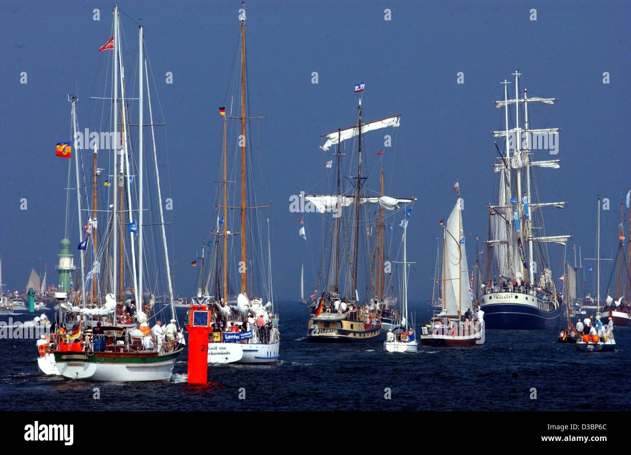 (Afp) - De nombreux bateaux à voile à régler leurs voiles qu'ils quittent le port dans Rostock-Warnemuende, Allemagne, le 9 août 2003. Plus de 250 bateaux à voile traditionnel musée et participera à la 13e 'Hanse Sail' régate de voile en mer Baltique. La ville de Rostock souligne à cet événement j Banque D'Images