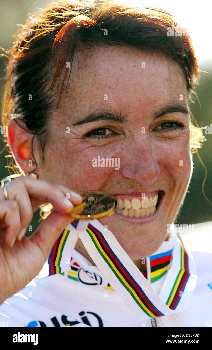 (Afp) - L'Espagne Joana Somarriba Arrola mord sur sa médaille d'or qu'elle a gagné à l'épreuve individuelle femmes race sur 20,5 km pendant la Championnat du monde de cyclisme à Hamilton, Canada, 8 octobre 2003. Banque D'Images