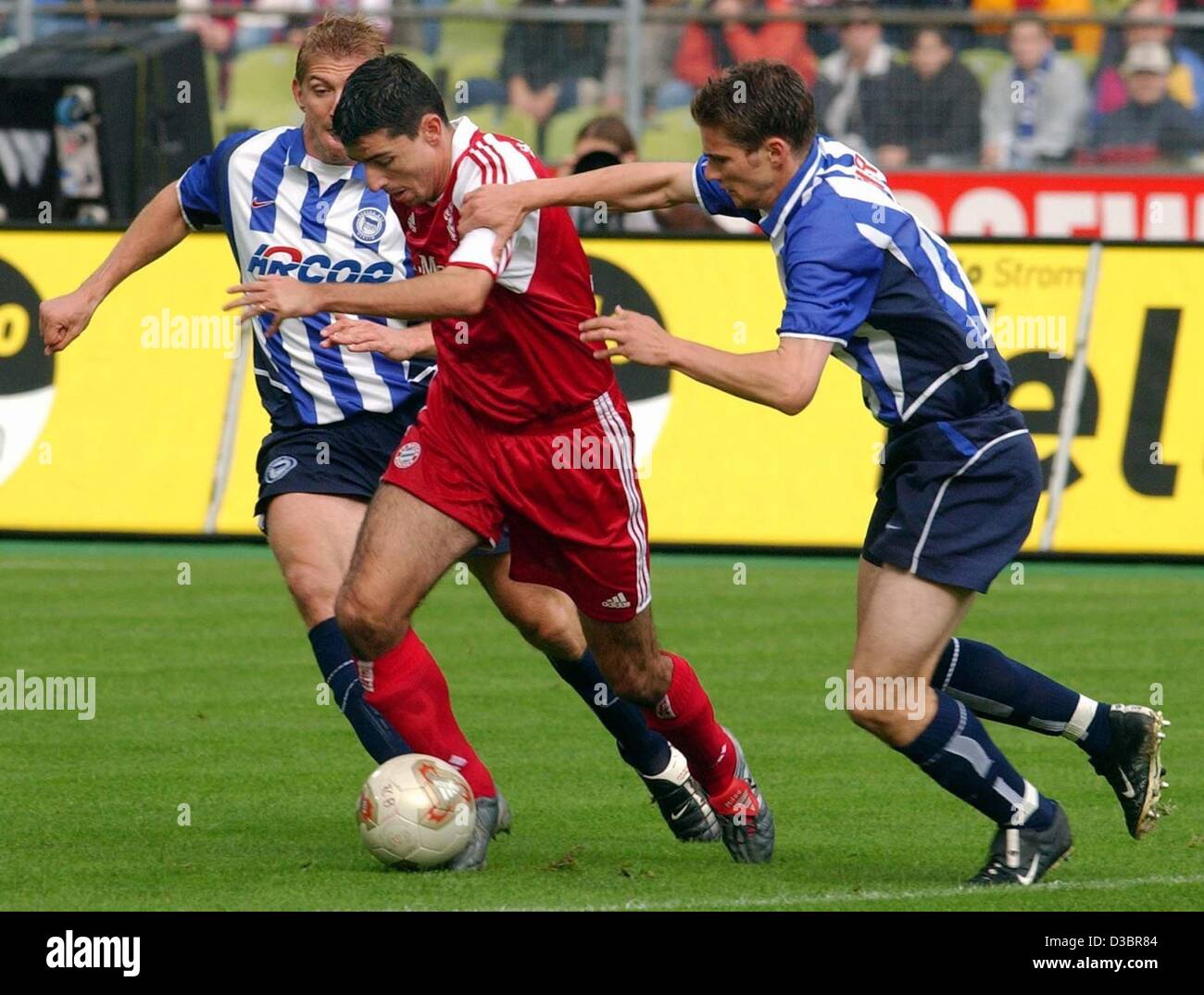 (Afp) - le Bayern joueur néerlandais Roy Makaay (C) se bat avec les défenseurs de Berlin Marko Rehmer (L) et Arne Friedrich durant la Bundesliga match contre FC Bayern Munich et Hertha BSC Berlin, à Munich, le 4 octobre 2003. Le détenteur du titre le Bayern de Munich gagne 4-1 et se classe quatrième dans le premier Allemand Banque D'Images