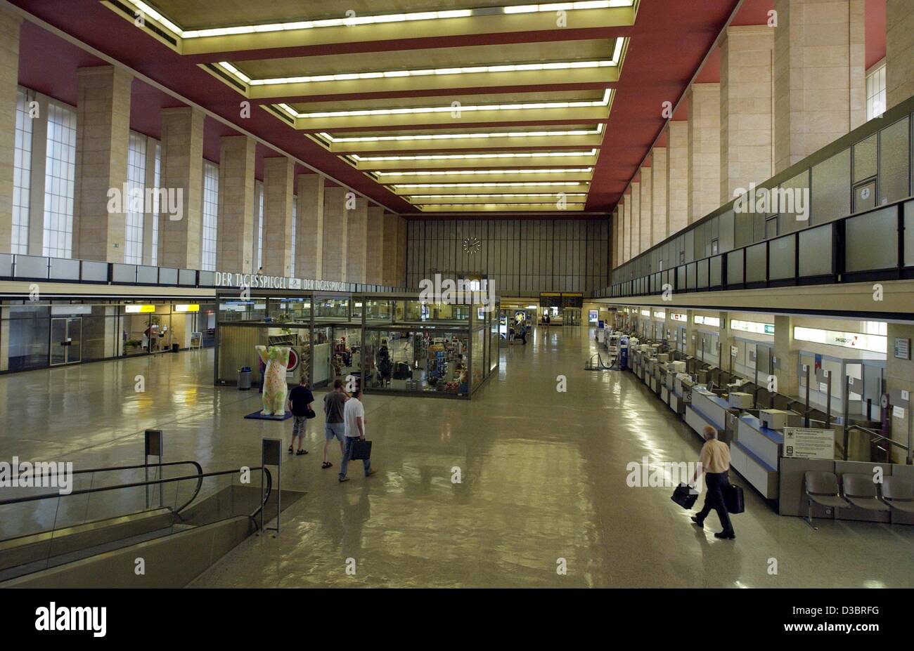 (Afp) - Les Voyageurs à pied à travers la salle d'enregistrement de l'aéroport de Tempelhof à Berlin, Allemagne, le 8 août 2003. L'aéroport a été créé en 1923 mais le bâtiment actuel a été construit au début des années 1930 par l'architecte allemand Ernst Sagebiel. Le style architectural allie le caractère fonctionnel de la Banque D'Images