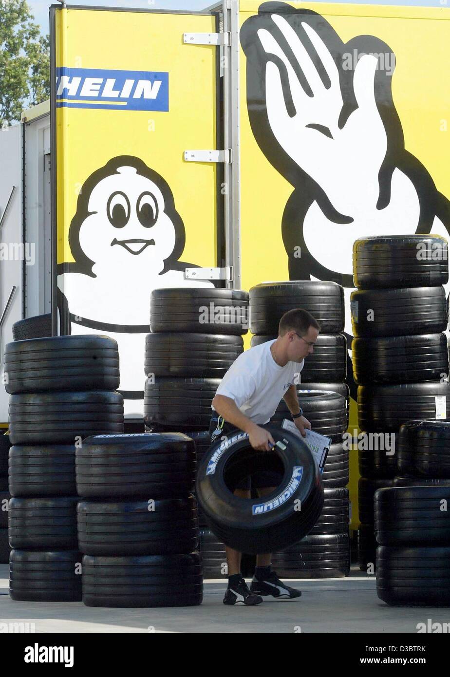 Afp) - Un technicien du fabricant de pneus Michelin choisit un pneu d'une  pile sur la piste de course de Formule 1 à Monza, Italie, le 11 septembre  2003. Le conseil d'administration