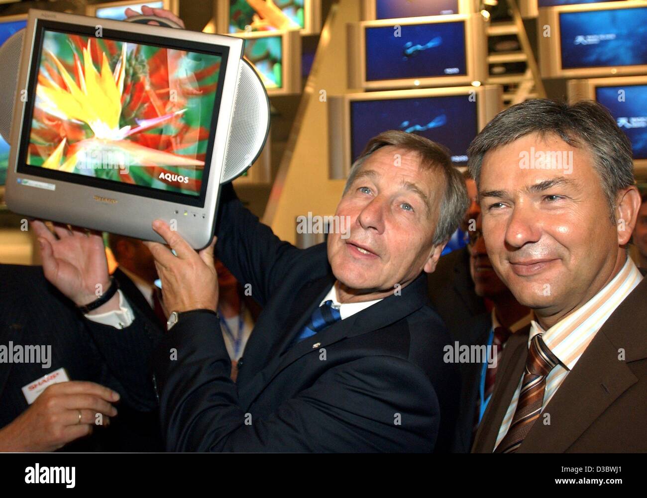 (Afp) - Le ministre allemand de l'économie, Wolfgang Clement (L) et le maire de Berlin Klaus Wowereit regarder ecrans plats pendant leur ouverture à pied autour de la 44e Internationale Funkausstellung IFA (International radio exposition) à Berlin, le 29 août 2003. La 44e CDI aura lieu du 29 août au 3 sept. Banque D'Images