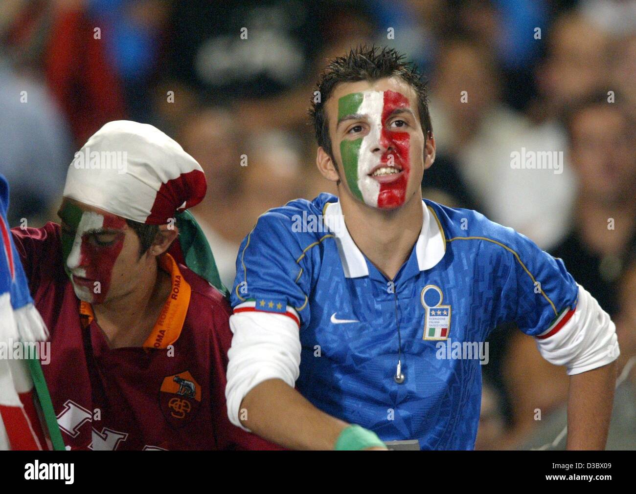 (Afp) - des fans de football italien ont peint leur visage dans leurs couleurs nationales et regarder le football match amical entre l'Allemagne et l'Italie à Stuttgart, Allemagne, 20 août 2003. L'Italie gagne 1-0. Banque D'Images
