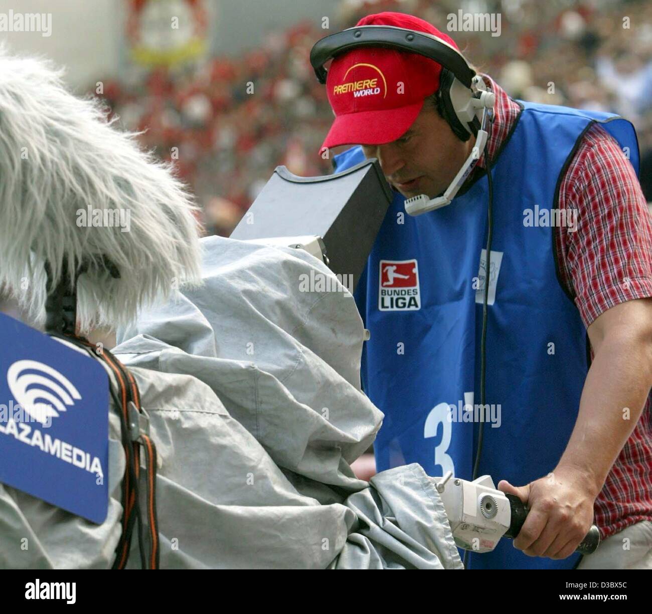 (Afp) - Un opérateur de caméra TV de la chaîne de télévision payante Premiere World films un jeu de football de la Bundesliga dans le stade de Leverkusen, Allemagne, 16 août 2003. Banque D'Images