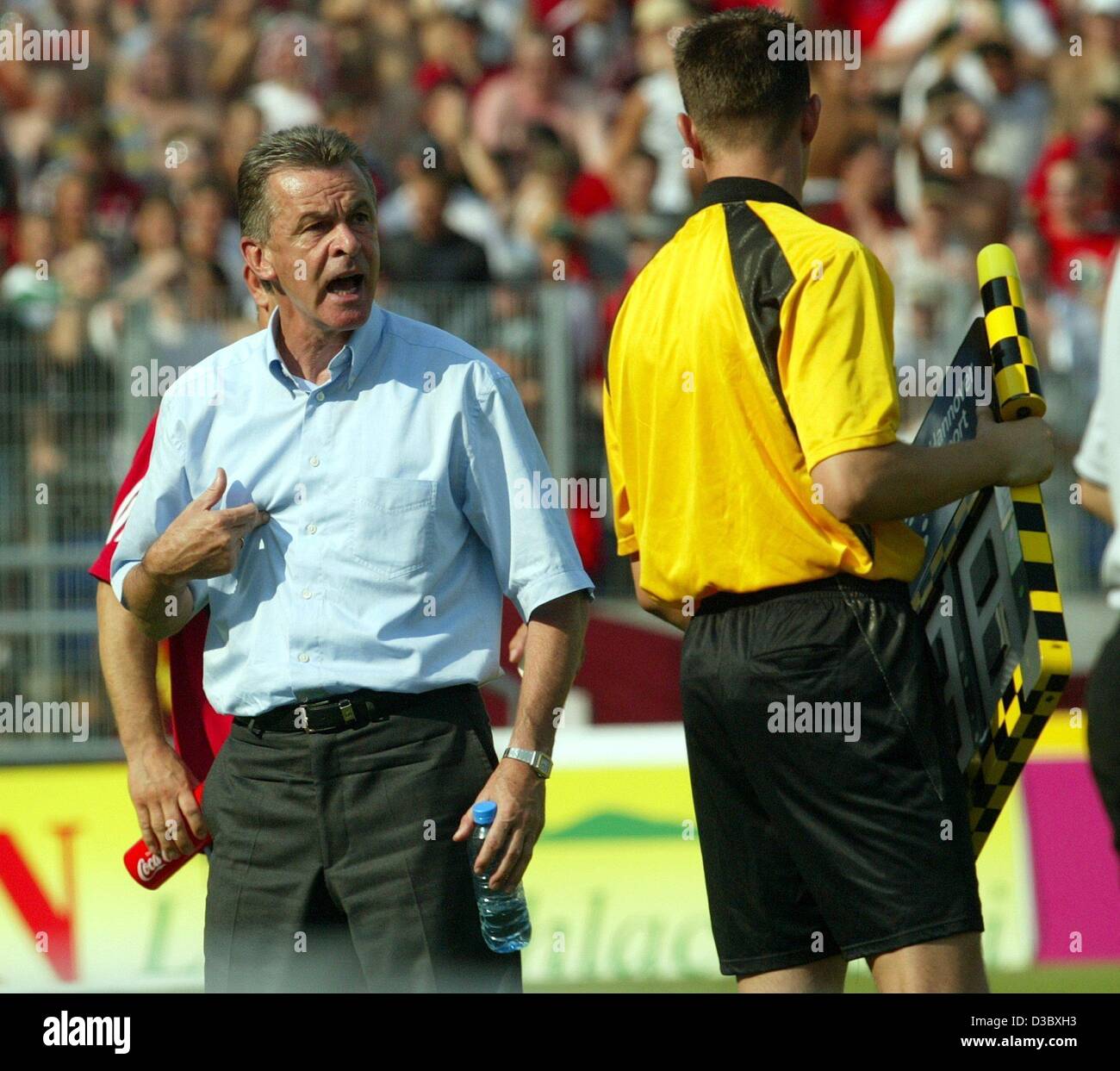 (Afp) - L'entraîneur de football Bayern Munich Ottmar Hitzfeld (R) affirme avec colère à l'arbitre assistand pendant la partie de football Bundesliga Hanovre 96 contre le FC Bayern Munich à Hanovre, Allemagne du 9 août 2003. Le jeu est terminé dans un 3-3 tie. C'était la journée la plus chaude de l'actuelle saison de Bundesliga avec tempe Banque D'Images