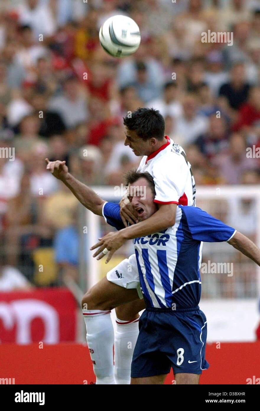 (Afp) le défenseur portugais de Stuttgart, Fernando Meira (haut) tombe sur le milieu de terrain belge de Berlin Bart Goor tandis que les deux lutte pour l'en-tête pendant le match de football de la Bundesliga contre le VfB Stuttgart Hertha BSC Berlin à Stuttgart, Allemagne, 10 août 2003. Le jeu est terminé dans un 0-0 tie. Banque D'Images