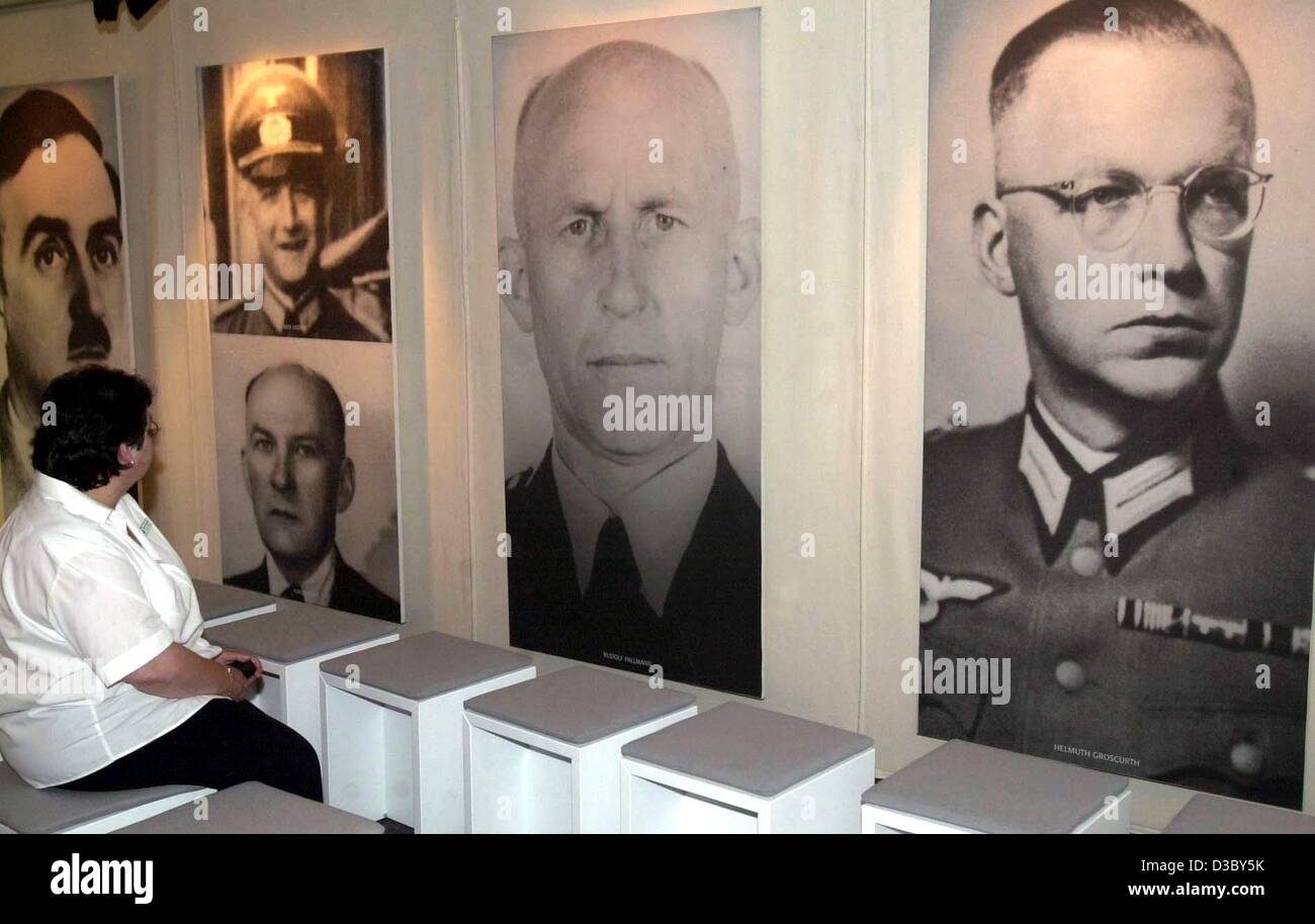 (Afp) - Un visiteur regarde des portraits d'officiers de la Wehrmacht, même si des déclarations des témoins d'époque sont entendues par haut-parleur à l'exposition sur les crimes de la Wehrmacht ('Verbrechen der Wehrmacht') dans le nord-est de l'Allemagne, Peenemuende, 23 juillet 2003. L'exposition itinérante affirme la thèse que Banque D'Images