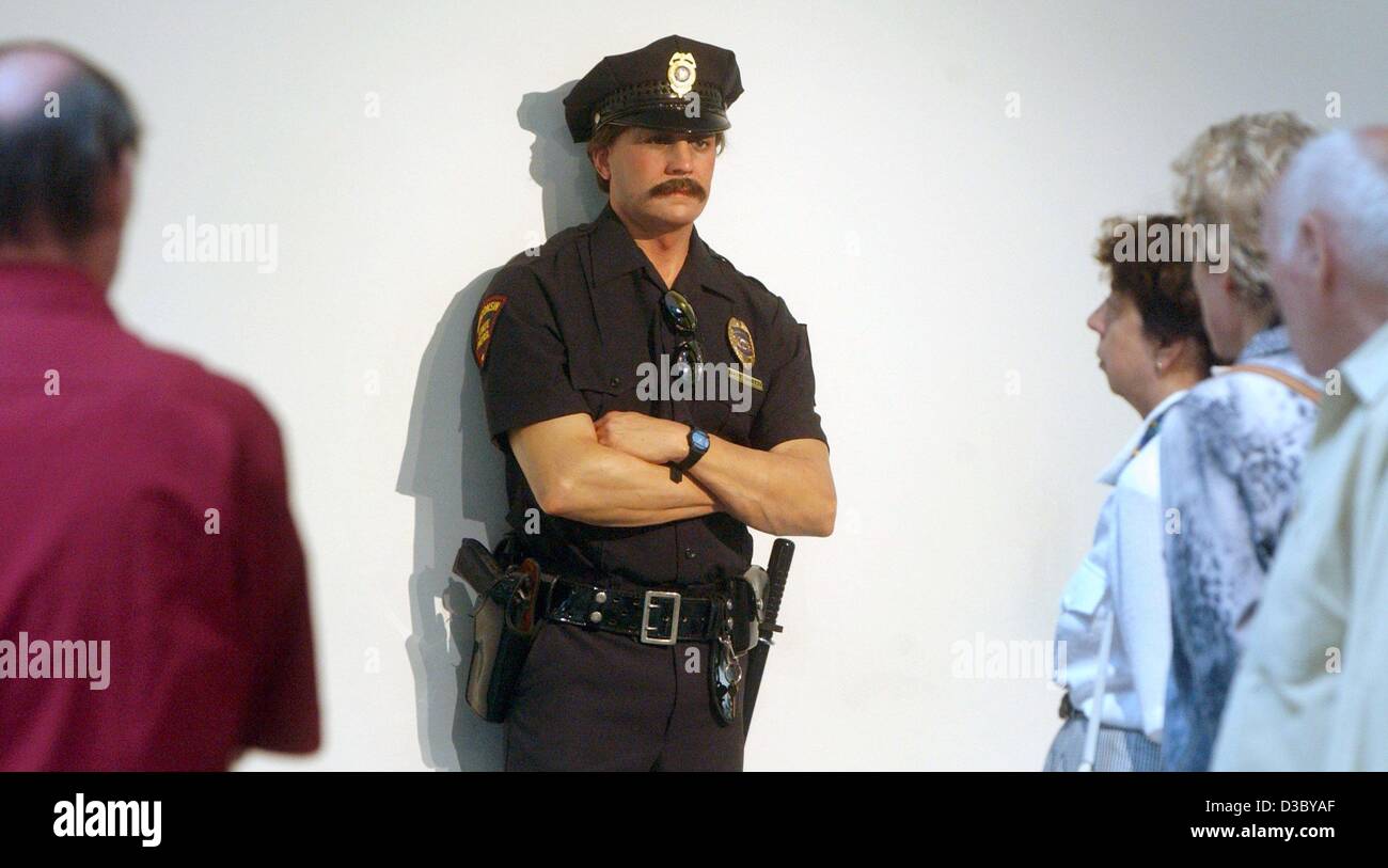 (Afp) - Les visiteurs regarder un vrai à propos policier, une sculpture de l'artiste américain Duane Hanson expose à la "plus que de la réalité' exposition à Berlin, 28 juillet 2003. Hanson a été influencé par le pop art quand il a commencé dans les années 1960 pour les répétitions des gens dans leur vie de tous les jours et Banque D'Images