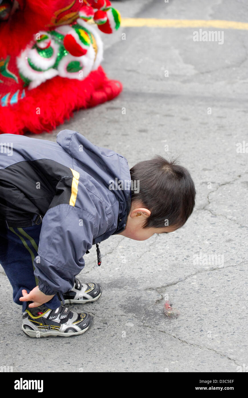 Jeune garçon chinois à regarder la masse au Nouvel An chinois pour l'année de l'Snake-Victoria, British Columbia, Canada. Banque D'Images