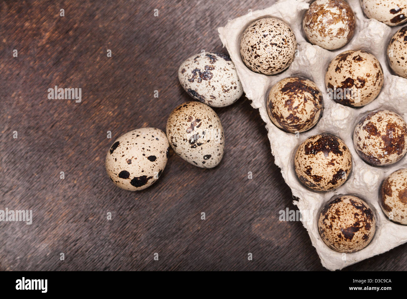 De nombreux produits frais oeufs de caille mouchetée en conteneur en carton sur bois Banque D'Images