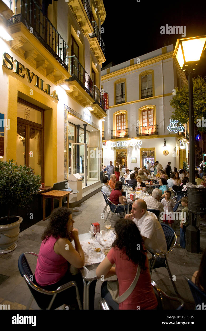 Diners à la terrasse d'un café de nuit hors d'un hôtel à Séville en Espagne. Banque D'Images