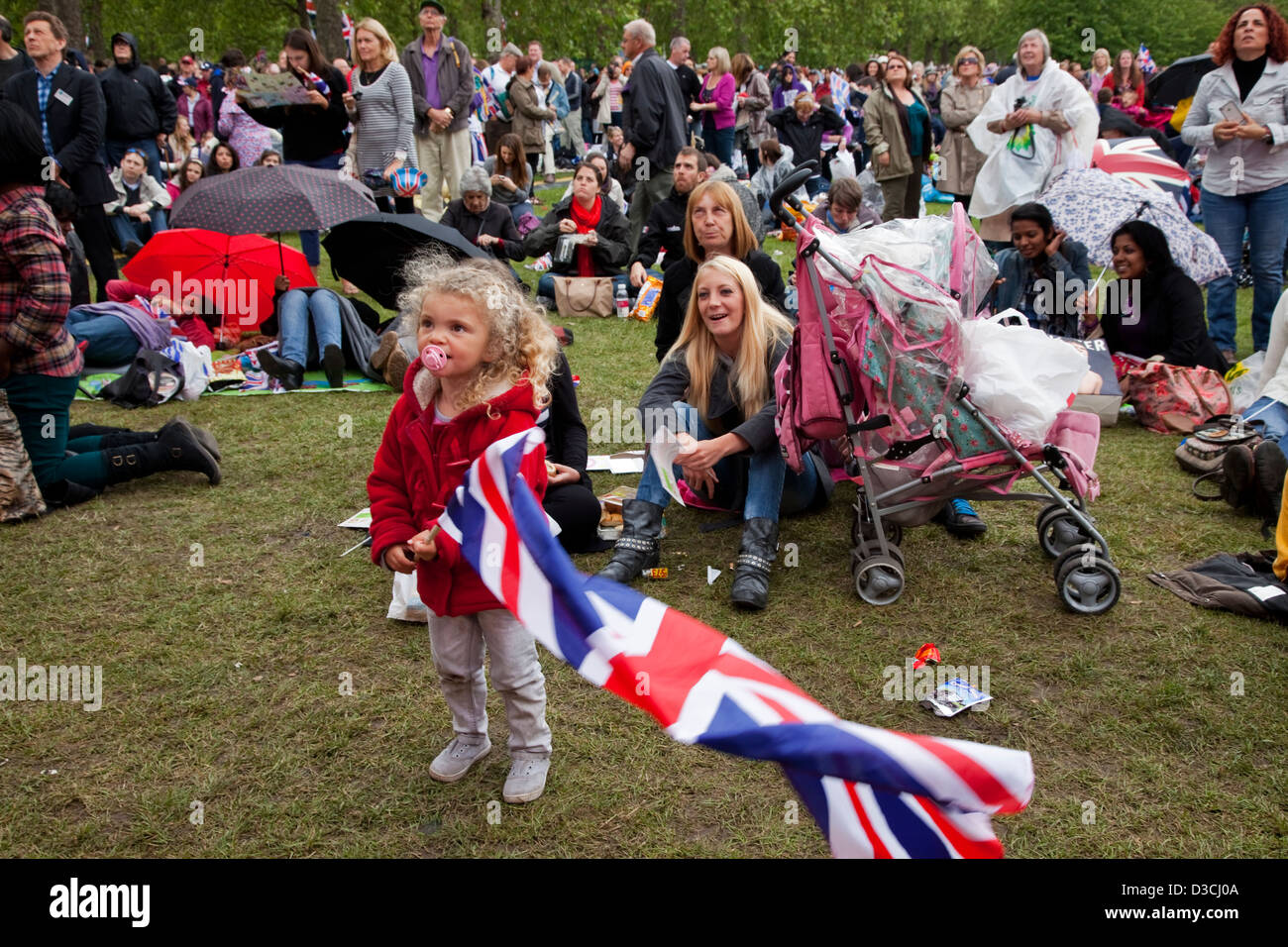 Les personnes qui participent à des célébrations du Jubilé de diamant à St James' Park regardent le cortège de la reine sur les écrans de plein air. Banque D'Images