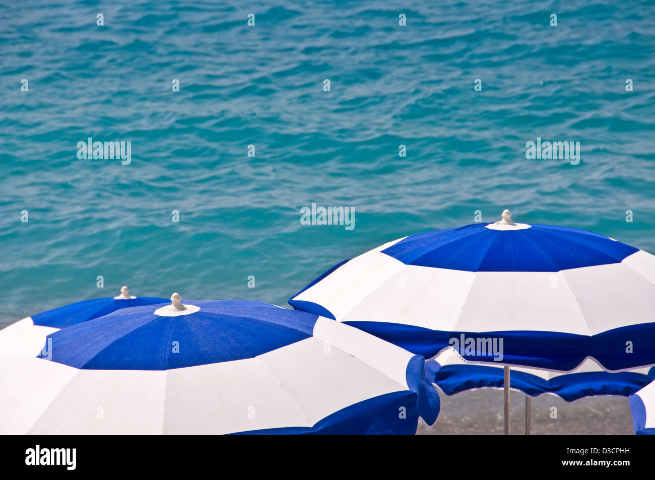 Plage privée avec des parasols de plage bleu et blanc, la mer en arrière-plan Vue de dessus - Nice, France Banque D'Images
