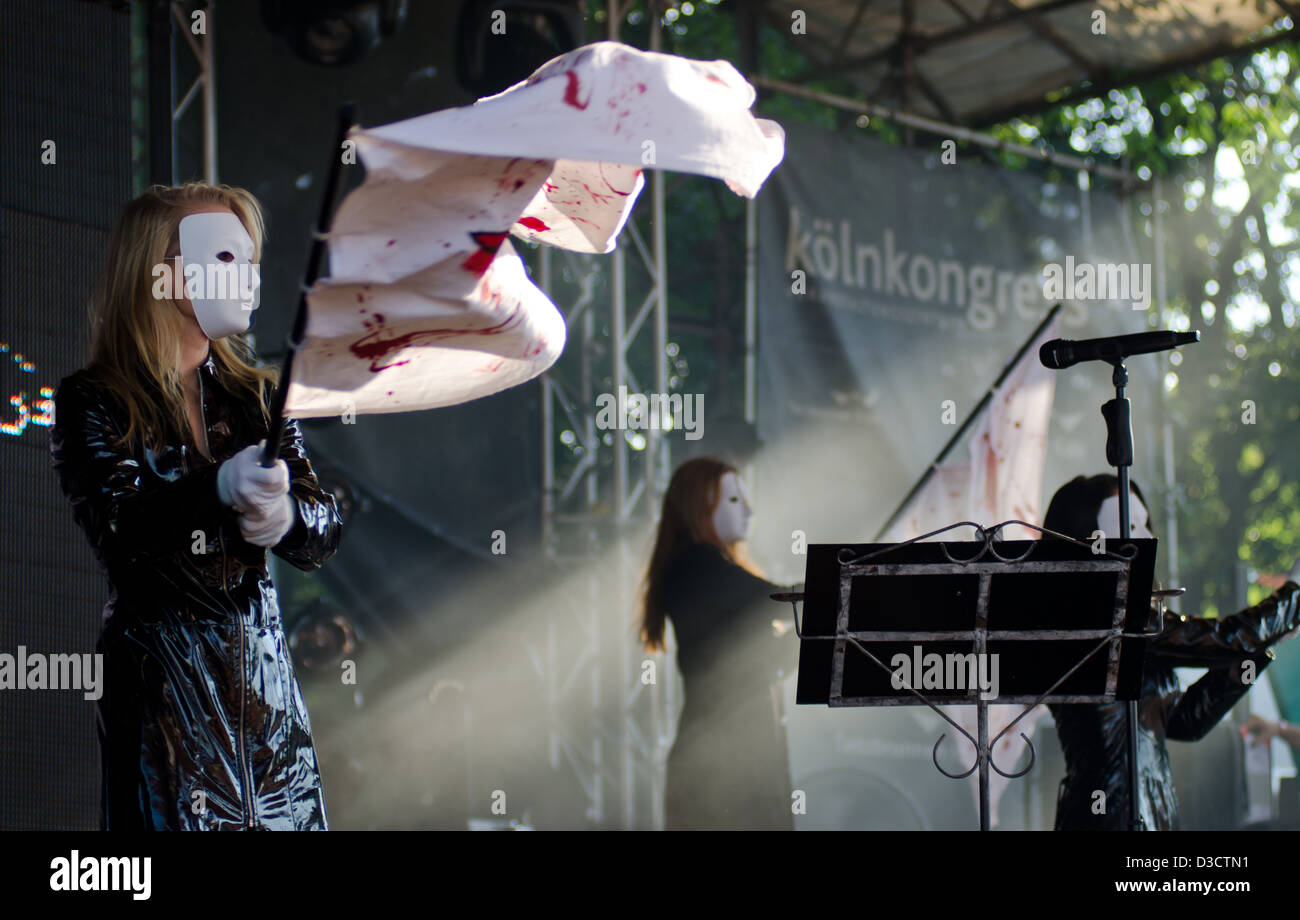 Danseurs masqués de la bande de goth allemand Blutengel brandissant des drapeaux sur scène à l'Amphi Festival 2012 Banque D'Images