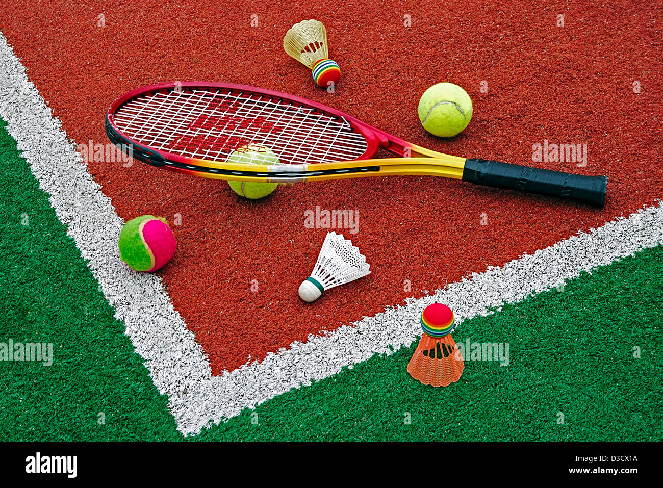 Badminton volants colorés avec balles et raquettes de tennis, placé dans le  coin d'un terrain synthétique Photo Stock - Alamy